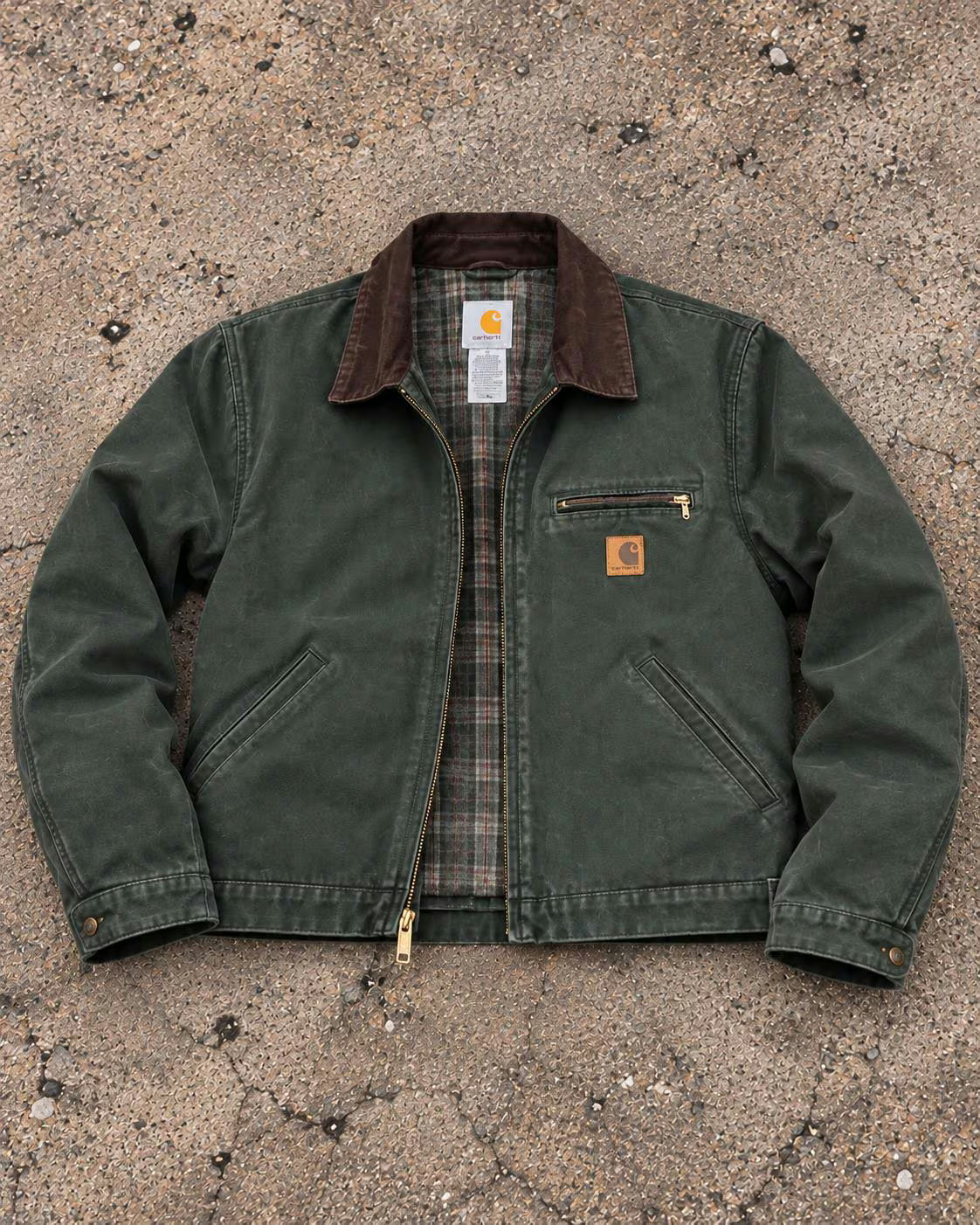 Veste de travail Carhartt verte, photographiée à plat sur du béton